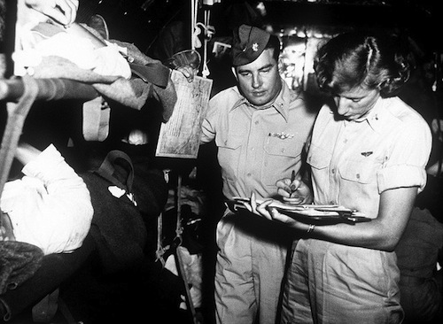 Flight nurse First Lieutenant Victoria Malokas is shown here with C-54 aircraft commander Major George Cichy, looking over patient records in October 1952..jpg